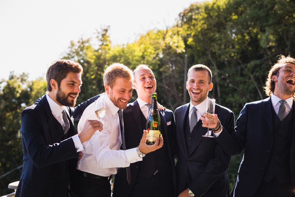 Wedding Photographer Como Lake Lo sposo brinda con i suoi amici sorridenti