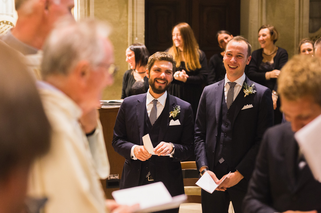Wedding Photographer Como Lake I testimoni dello sposo ridono durante la cerimonia in chiesa