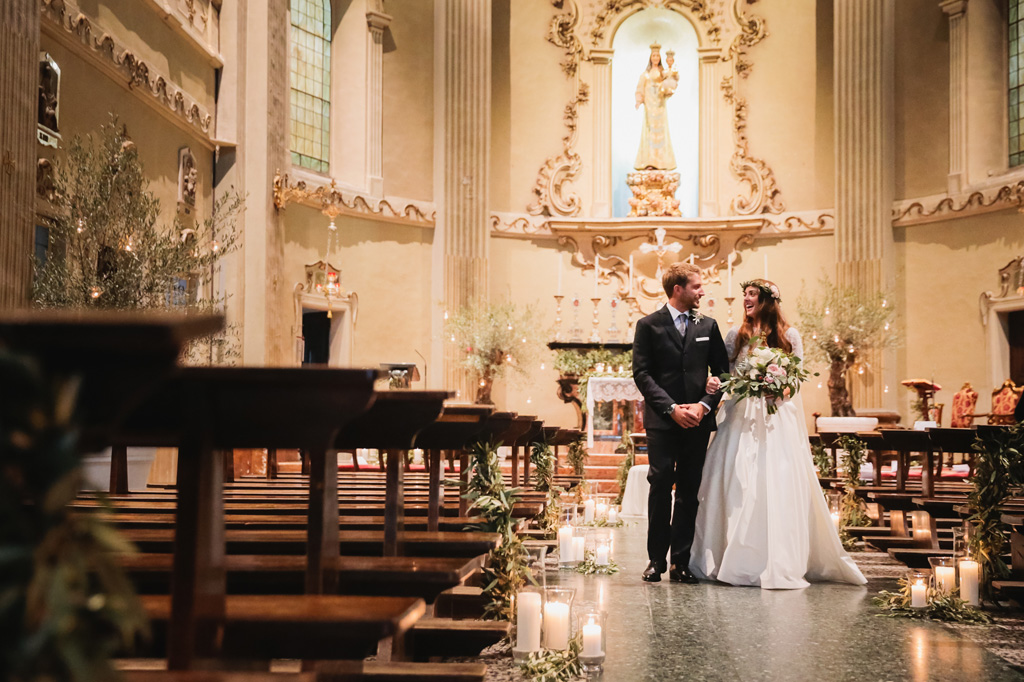 Wedding Photographer Como Lake Gli sposi si avviano verso l'uscita della chiesa percorrendo la navata principale