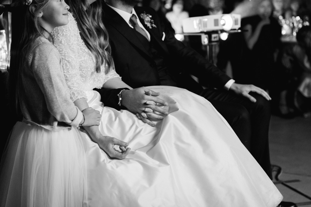 Wedding Photographer Como Lake Gli sposi si tengono per mano mentre guardano il video creato dagli amici