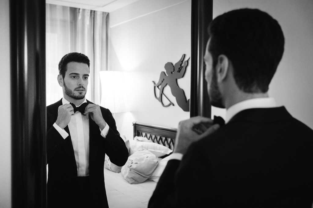 Fotografo Matrimonio Lago di Como Casta Diva Mandarin Lo sposo sistema il papillon allo specchio