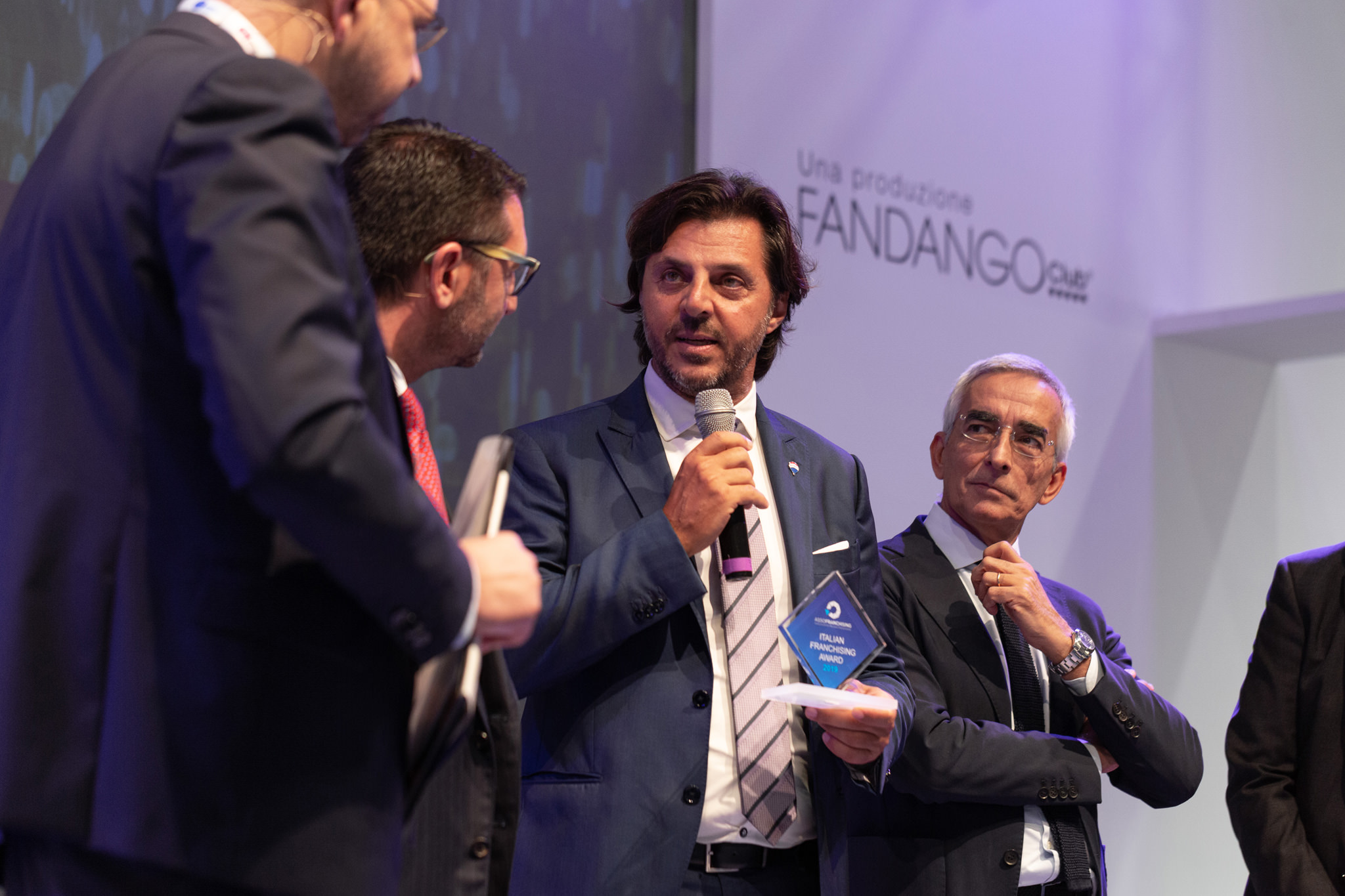 Fotografo Eventi Esclusivi Aziendali Fiera Milano Assofranchisin Un vincitore del premio Assofranchising Award enuncia un discorso per congratularsi con la giuria