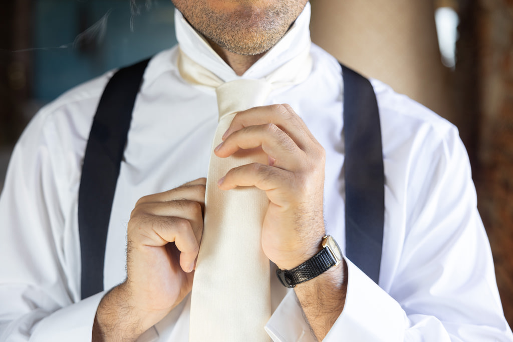 Destination Wedding Photographer Tuscany Italy Uno sposo che si mette una cravatta