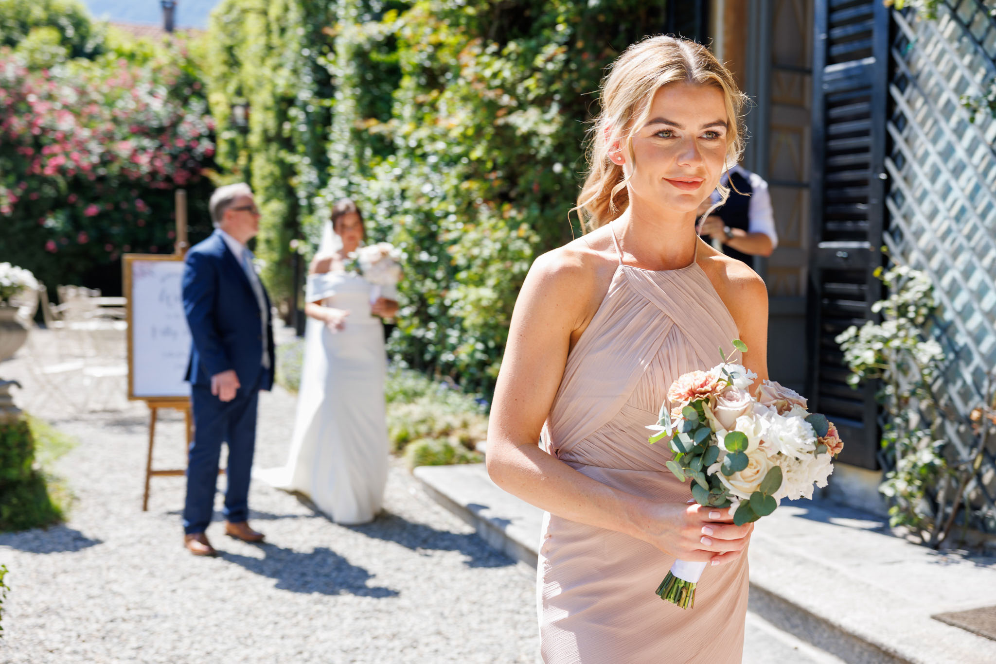 Destination Wedding Photographer Como Damigella su navata con la sposa e suo padre al matrimonio