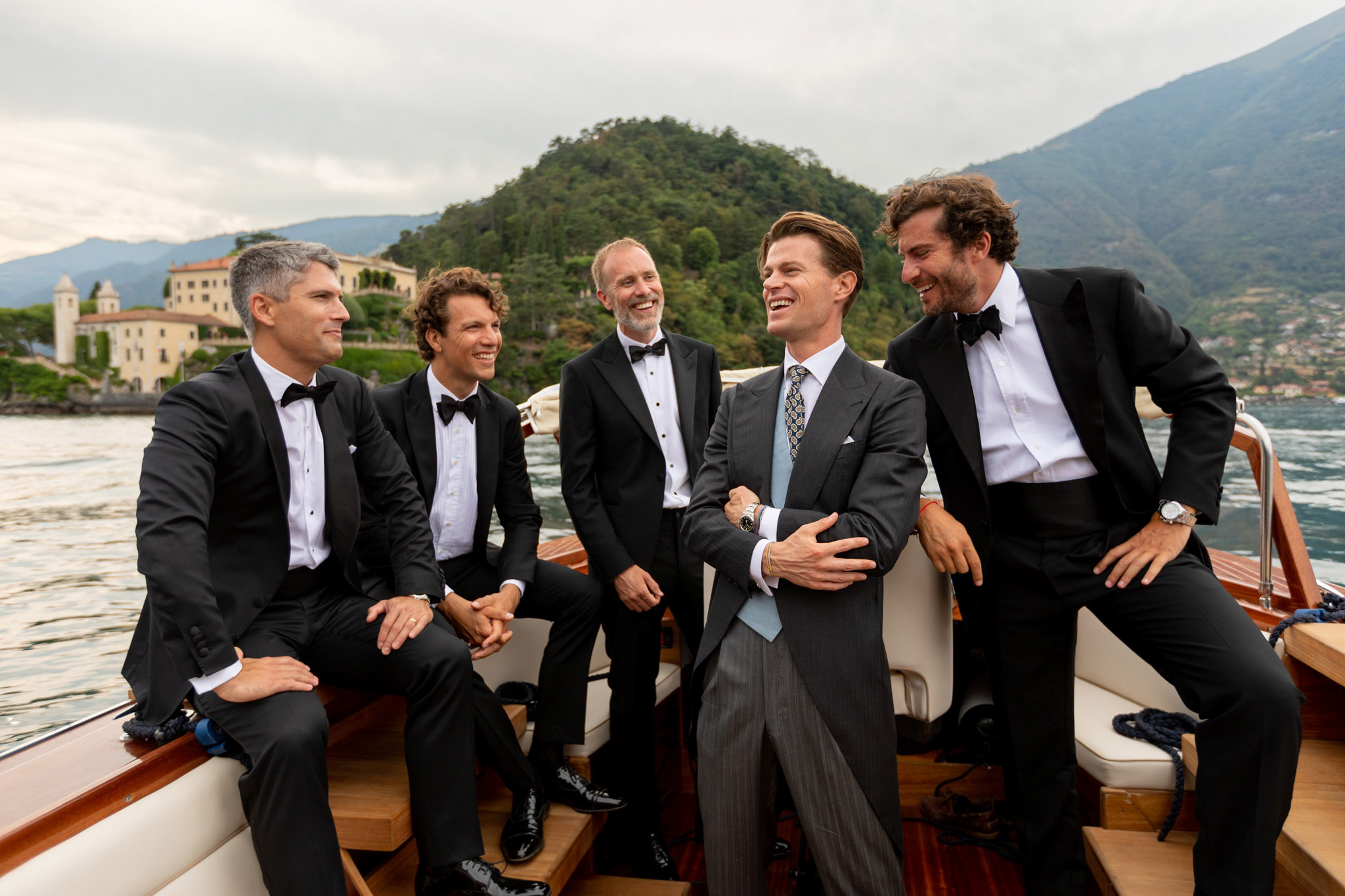 Destination Wedding Photographer Lake Como Uno sposo su una barca sul lago di como insieme agli invitati