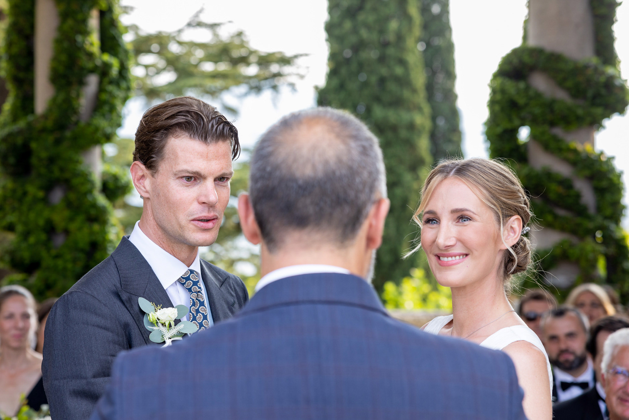 Destination Wedding Photographer Lake Como Una coppia di sposi che guardano il cerimoniere il giorno delle loro nozze