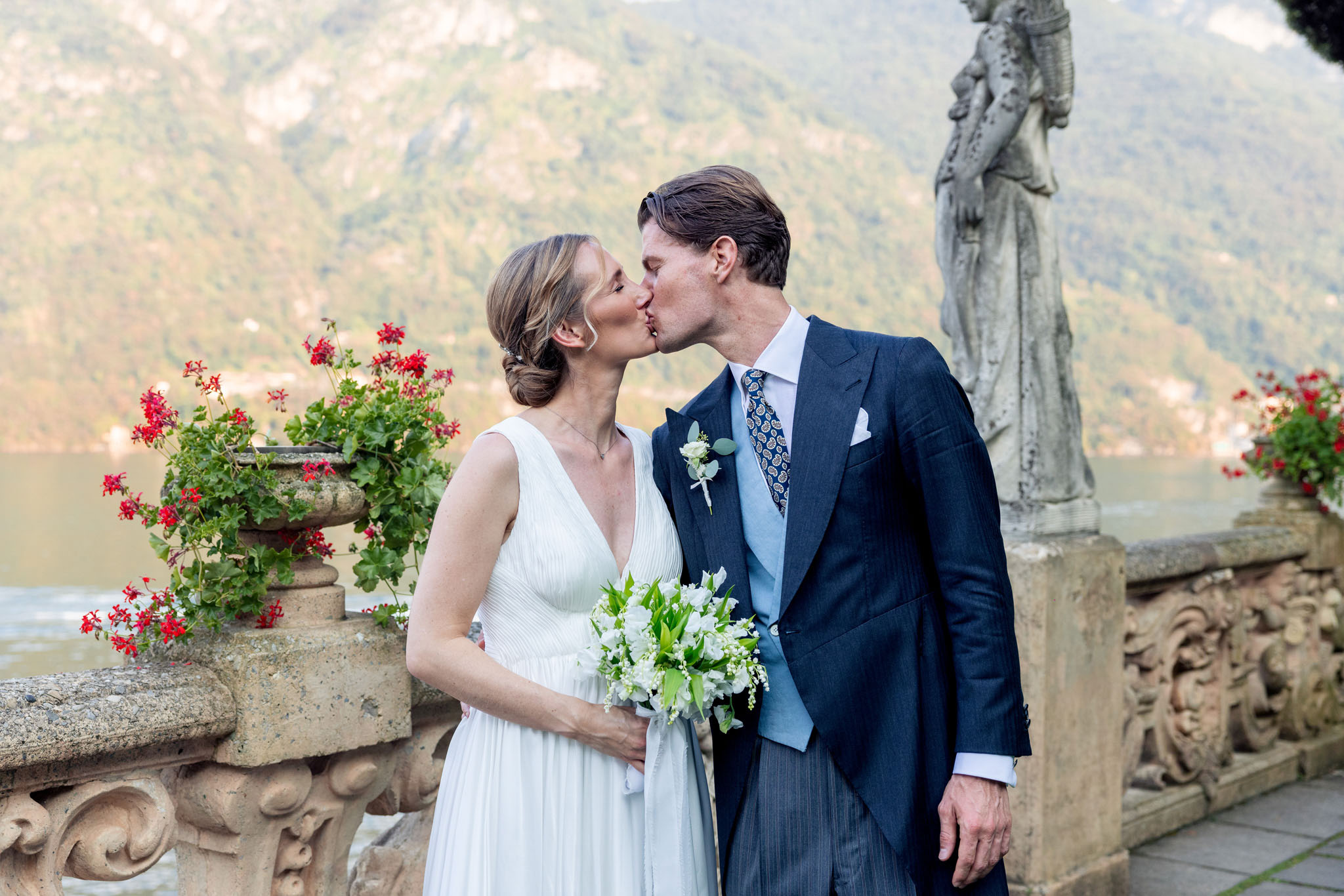 Destination Wedding Photographer Lake Como Gli sposi che si baciano nel giardino di una villa sul lago di Como