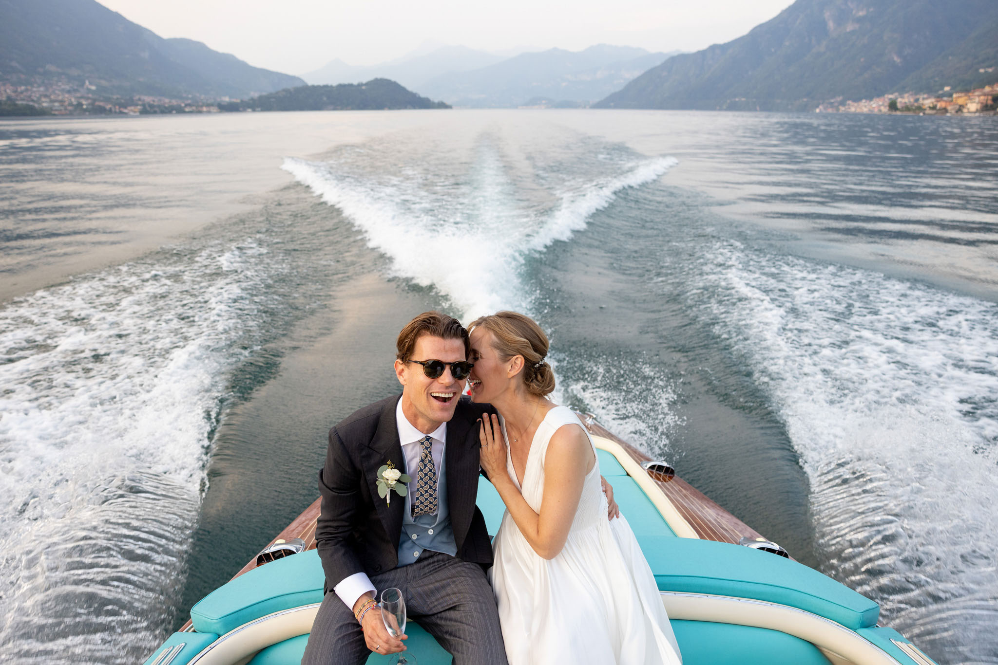 Destination Wedding Photographer Lake Como Due sposi che ridono su una barca sul lago di Como