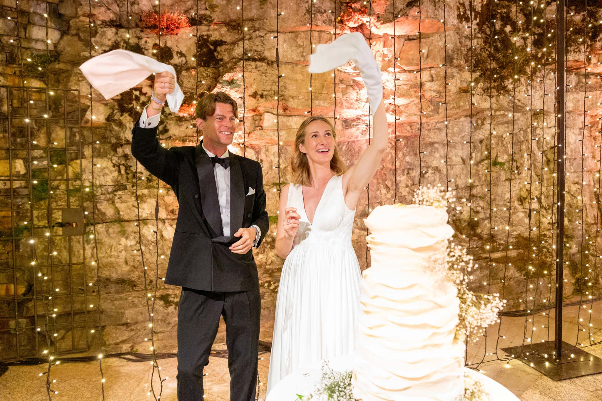 Destination Wedding Photographer Lake Como Una coppia di sposi che agita un tovagliolo il giorno del loro matrimonio