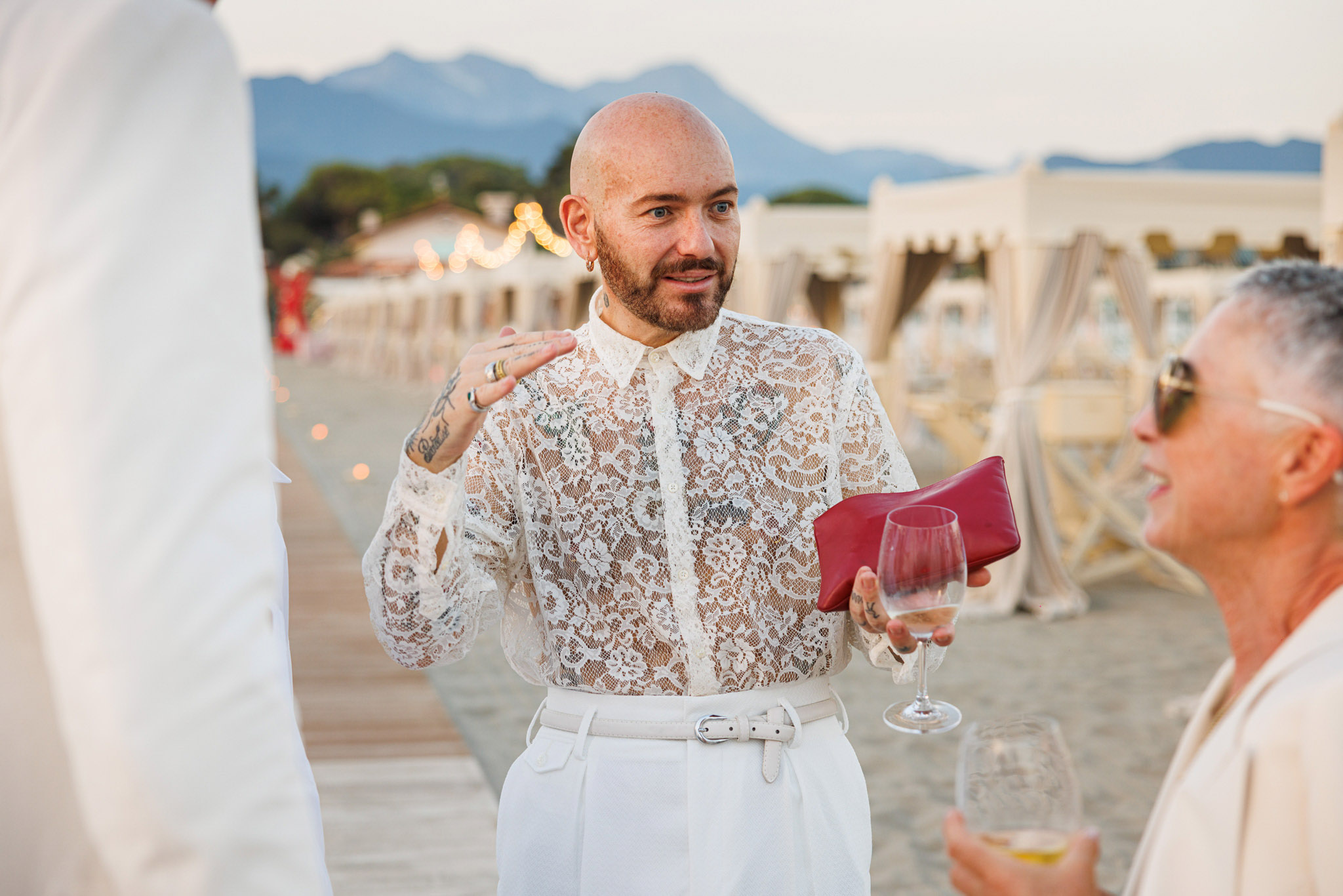 Destination Wedding Tuscany Un invitato che parla con altri il giorno delle nozze sulla spiaggia
