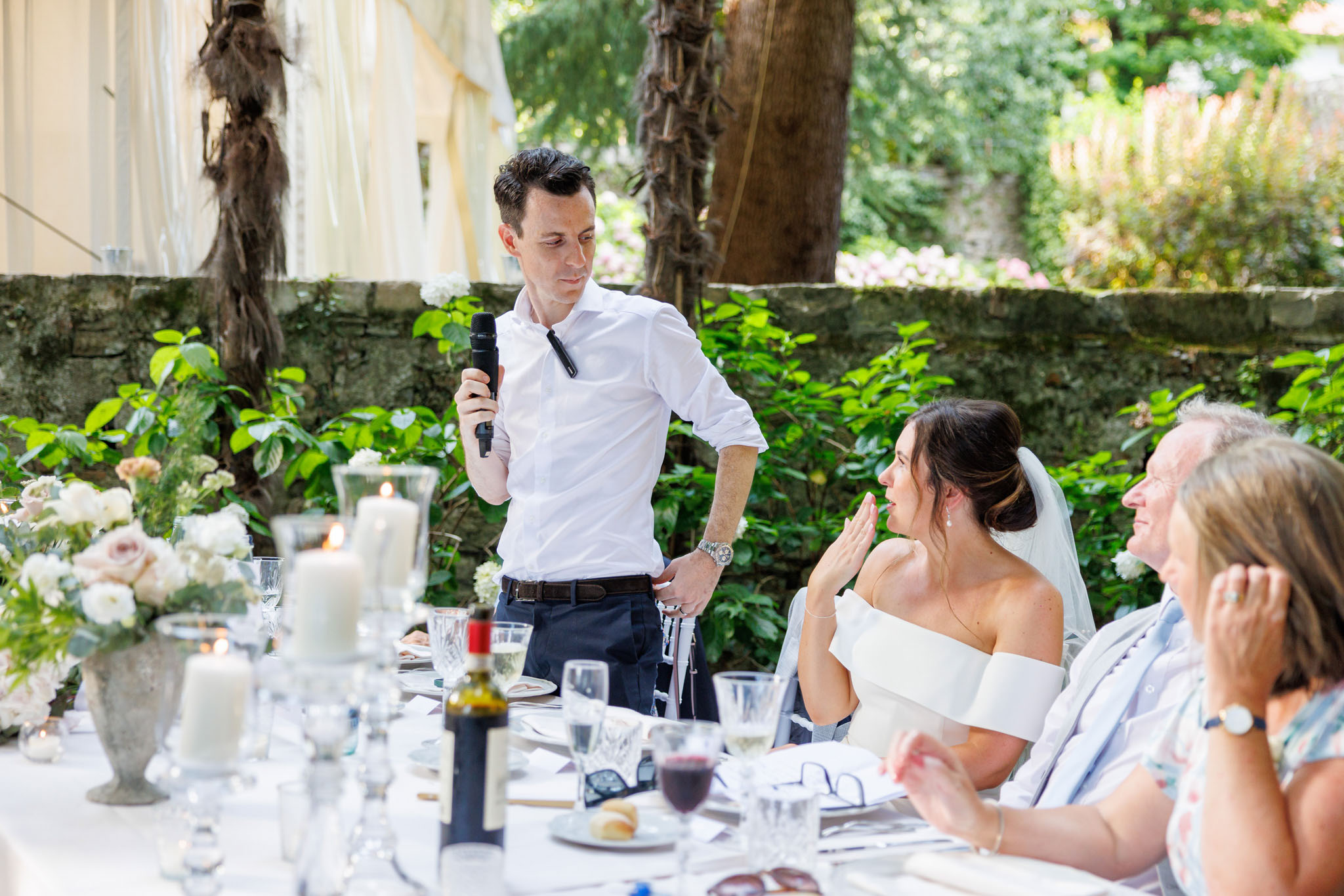 Destination Wedding Photographer Como Uno sposo che guarda la sposa mentre fa il discorso di nozze