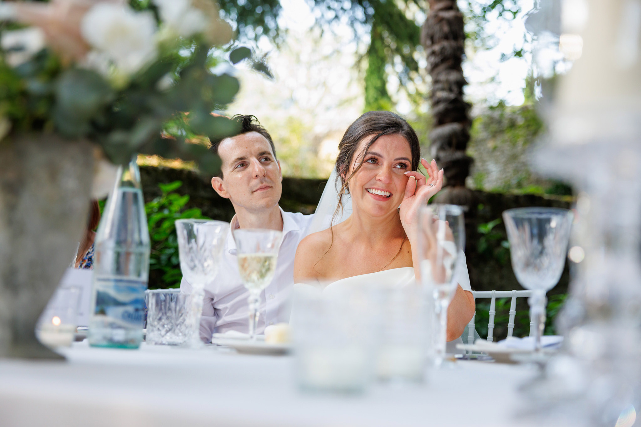 Destination Wedding Photographer Como Una sposa e uno sposo emozionati seduti al tavolo del loro matrimonio