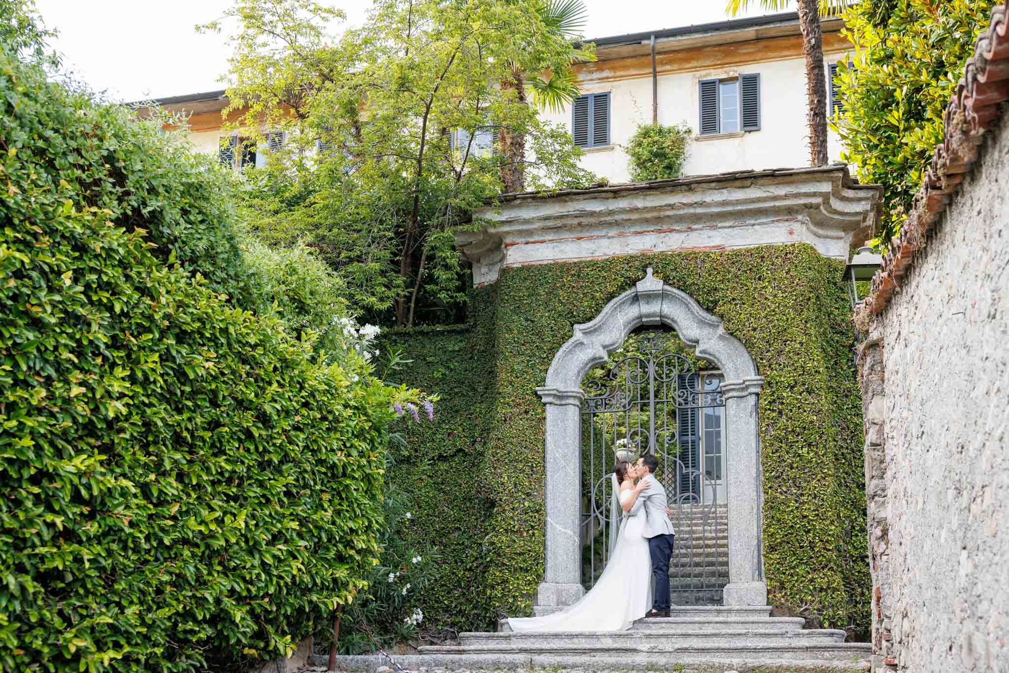 Destination Wedding Photographer Como Una coppia di sposi che si baciano alle porte di una villa sul lago di Como