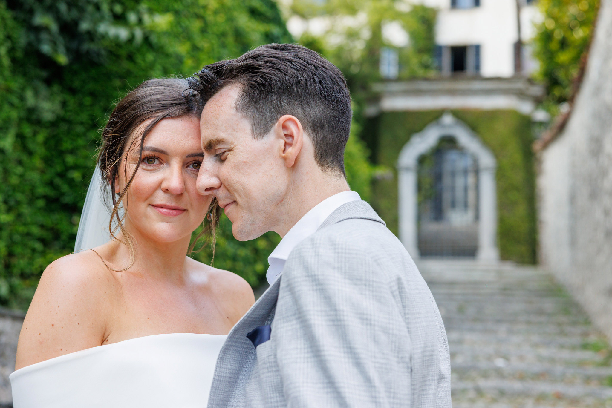 Destination Wedding Photographer Como Uno sposo e una sposa alle porte di una villa sul lago di Como