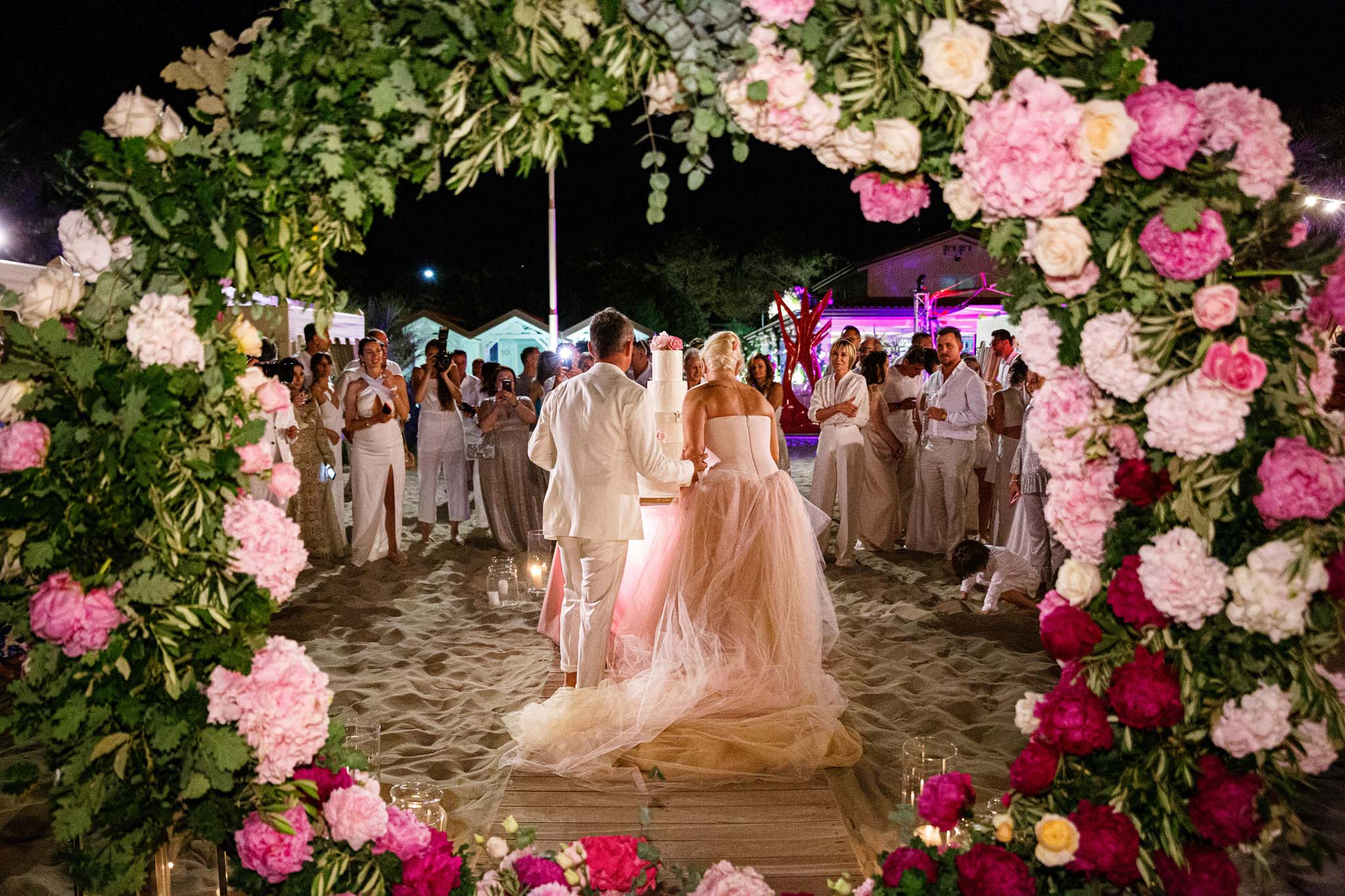Destination Wedding Tuscany Gli sposi che tagliano la torta nuziale del loro matrimonio sulla spiaggia