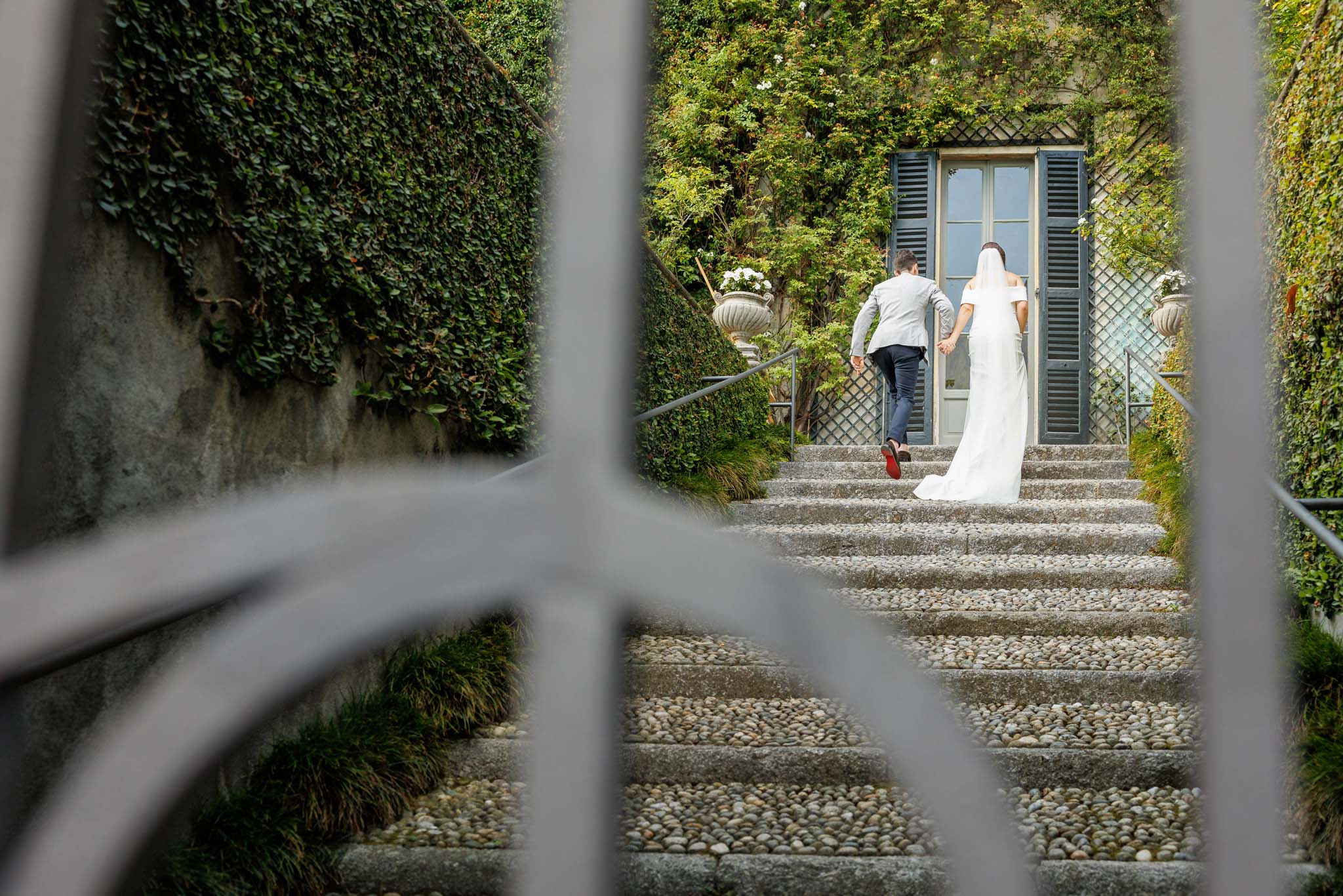 Destination Wedding Photographer Como Uno sposo e una sposa che entrano in una villa sul lago di Como