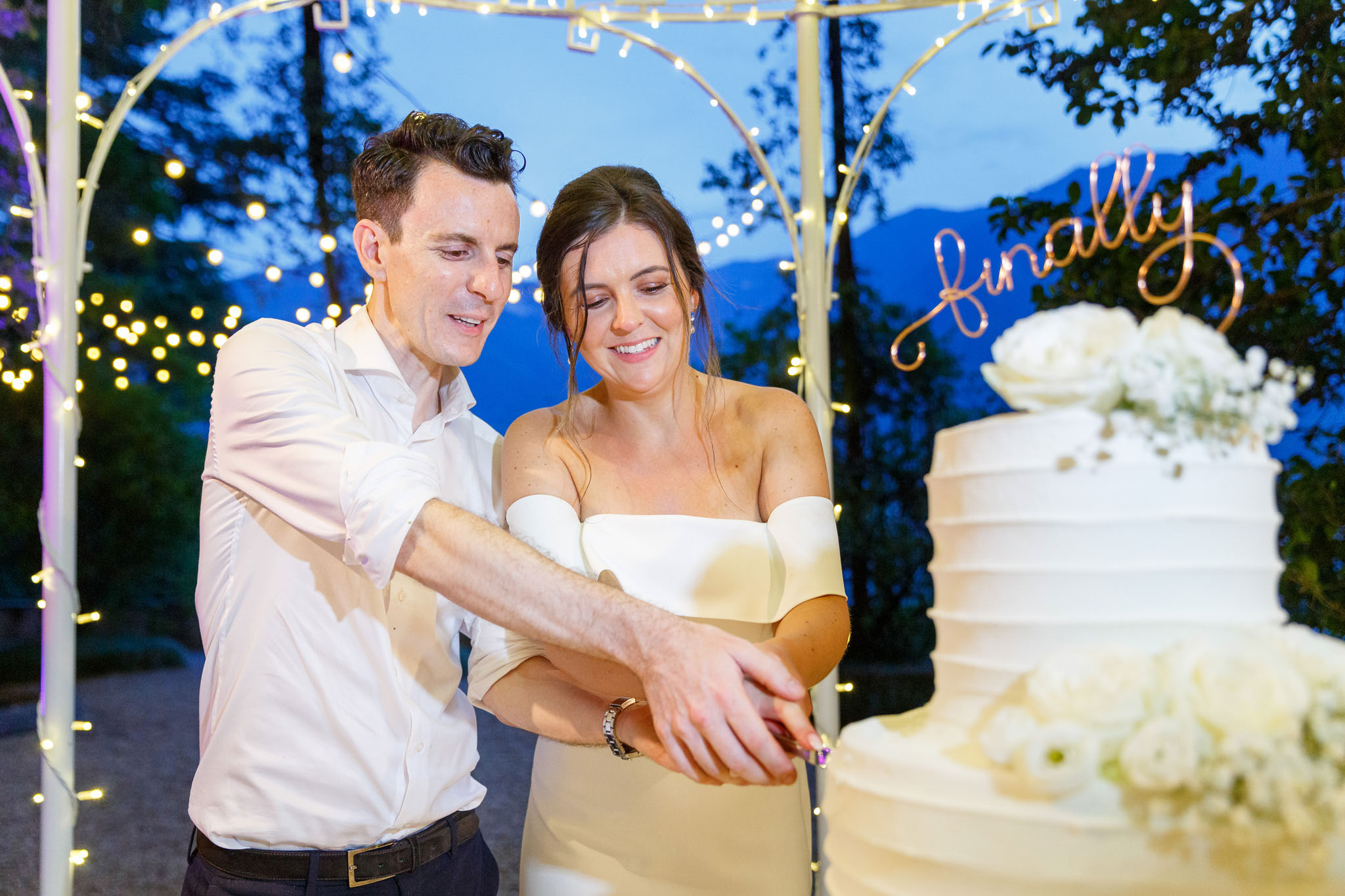 Destination Wedding Photographer Como Una coppia di sposi al taglio della torta al loro matrimonio