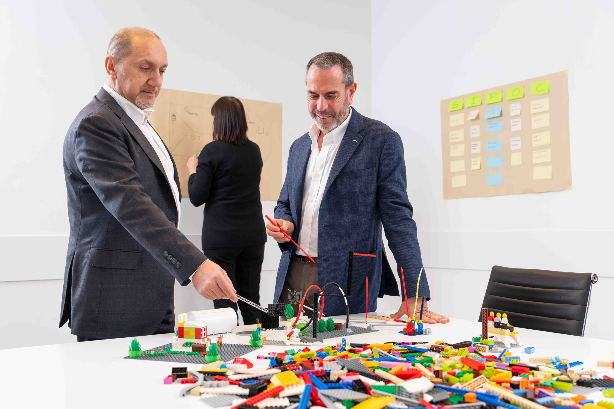 Foto business KyreTeam Colleghi che lavorano insieme con lego e lavagna