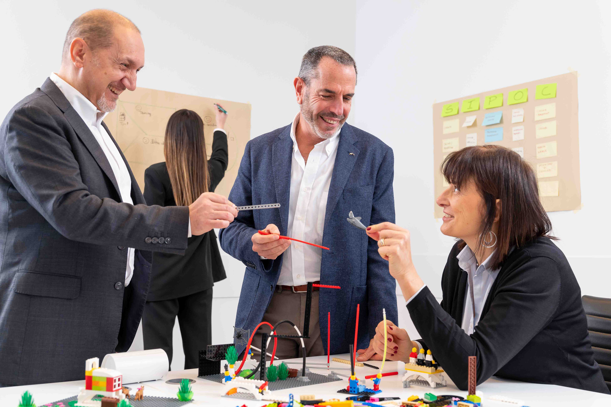 Foto business KyreTeam Colleghi che lavorano insieme con lego e lavagna