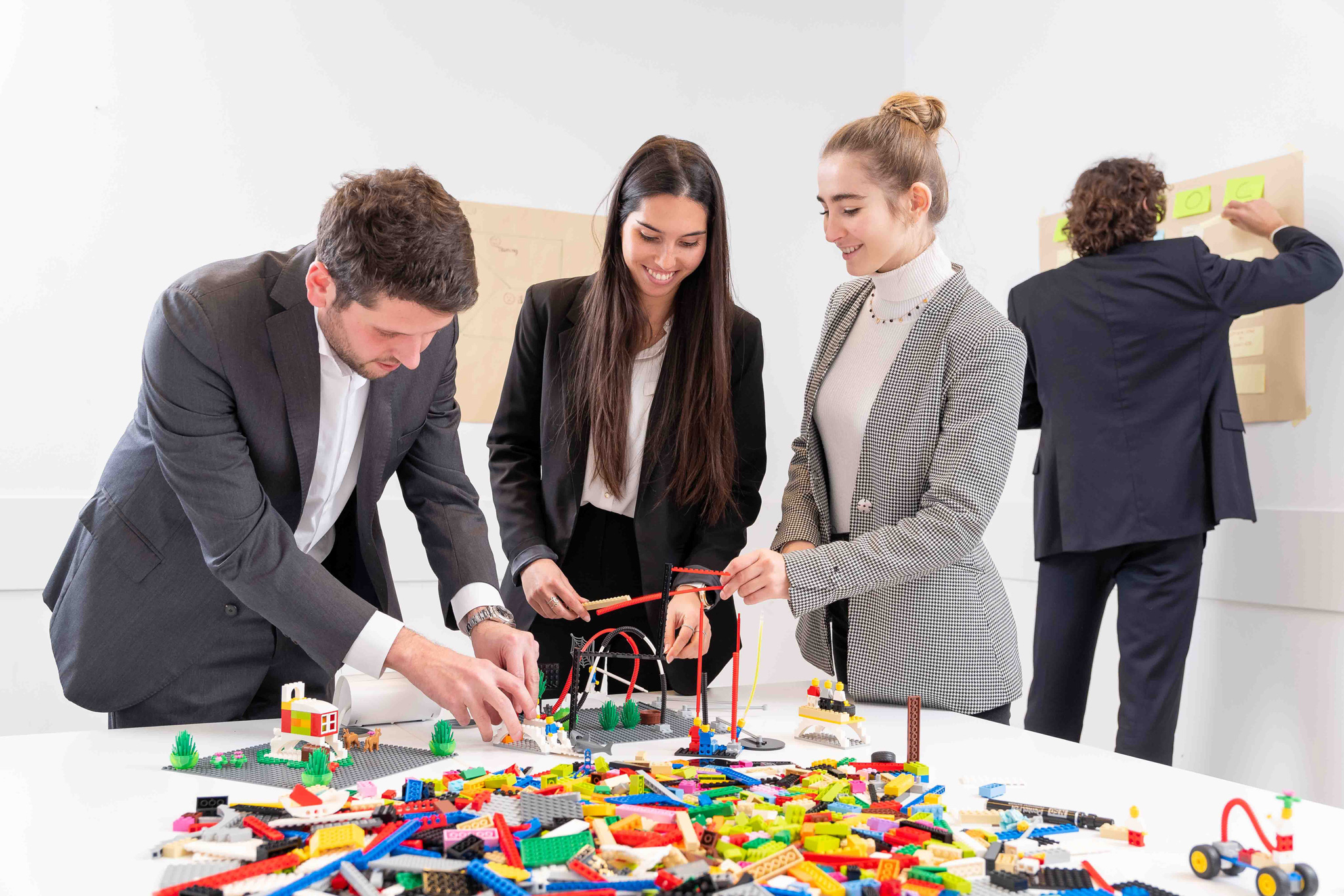 Foto business KyreTeam Colleghi che lavorano insieme con lego e lavagna