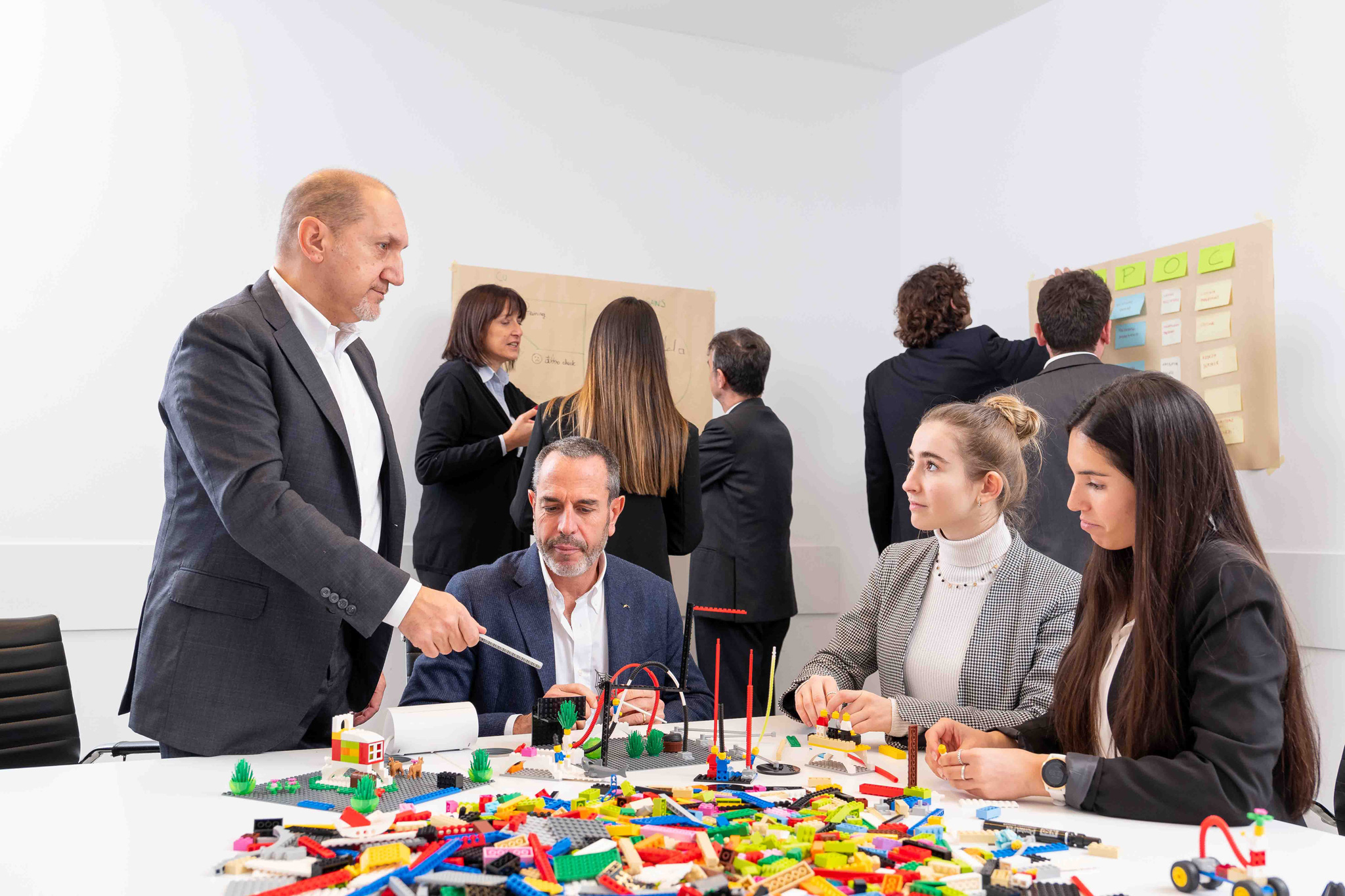 Foto business KyreTeam Colleghi che lavorano insieme con lego e lavagna