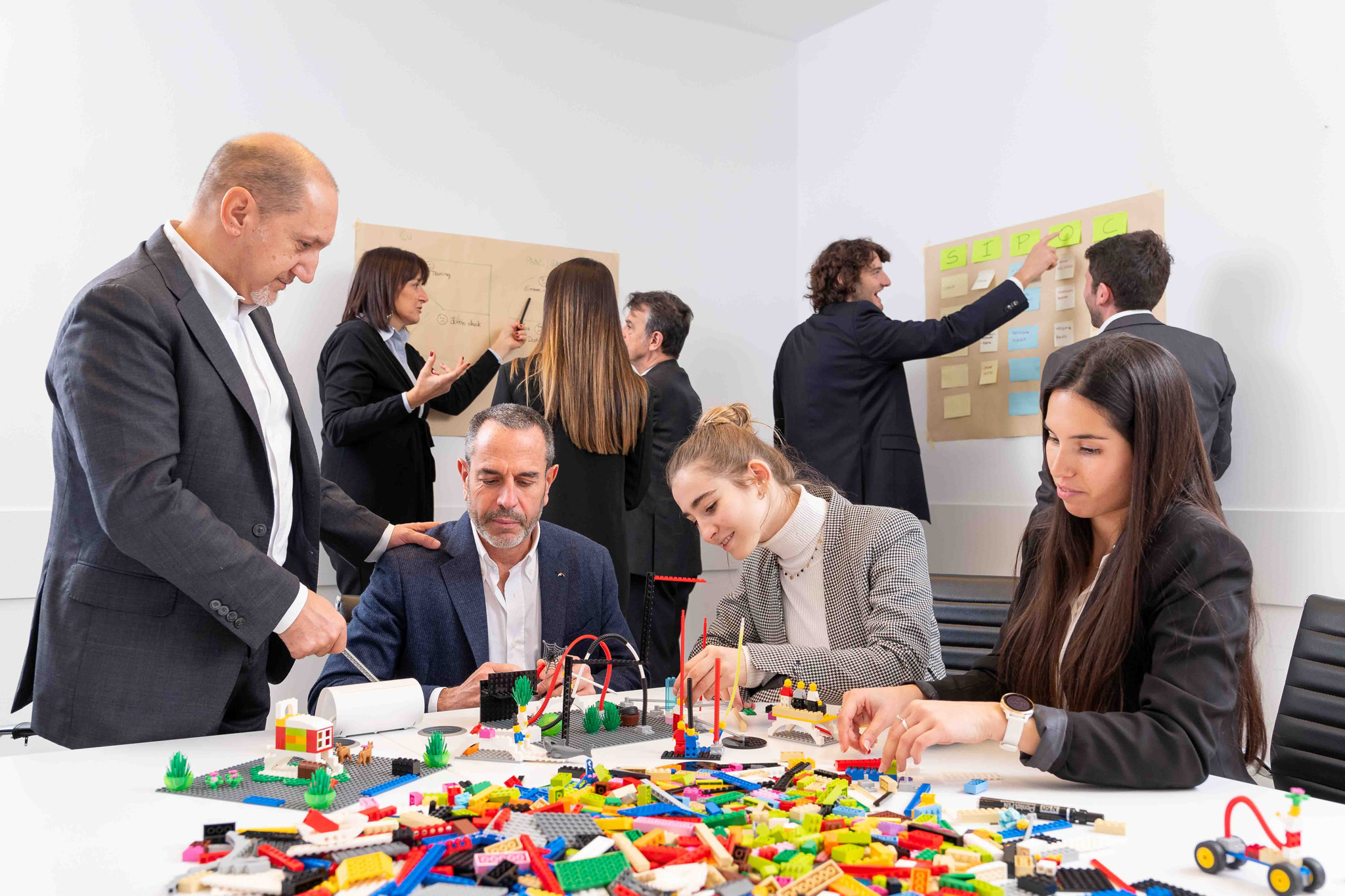 Foto business KyreTeam Colleghi che lavorano insieme con lego e lavagna
