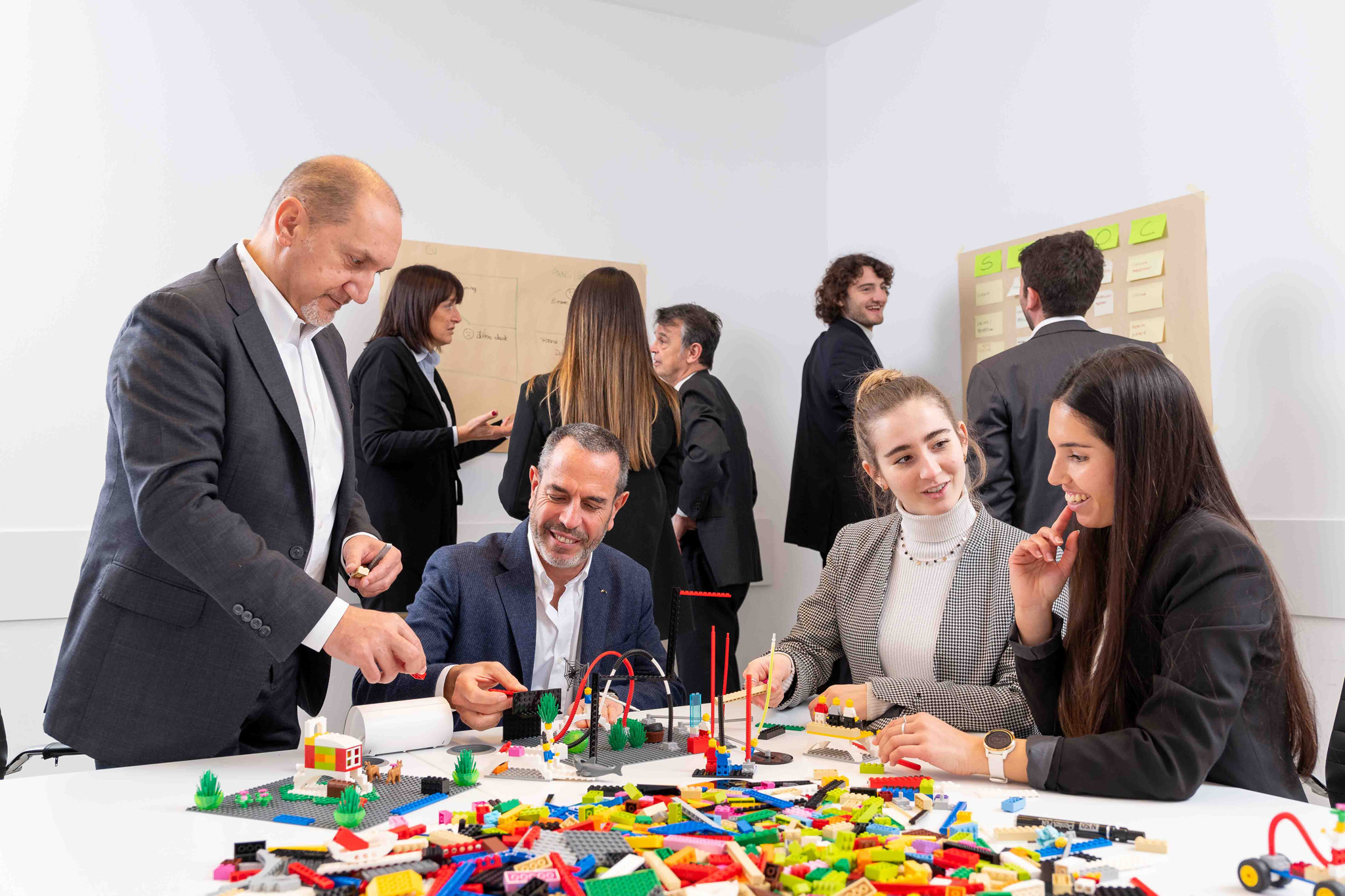 Foto business KyreTeam Colleghi che lavorano insieme con lego e lavagna