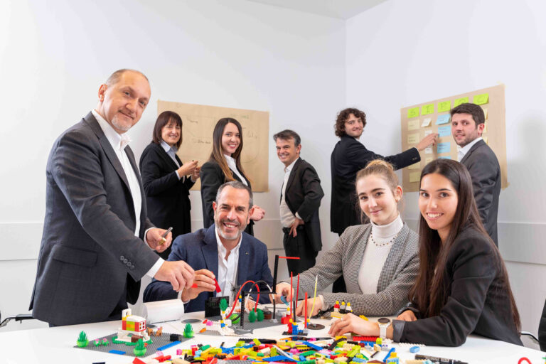 Colleghi che lavorano insieme con lego e lavagna