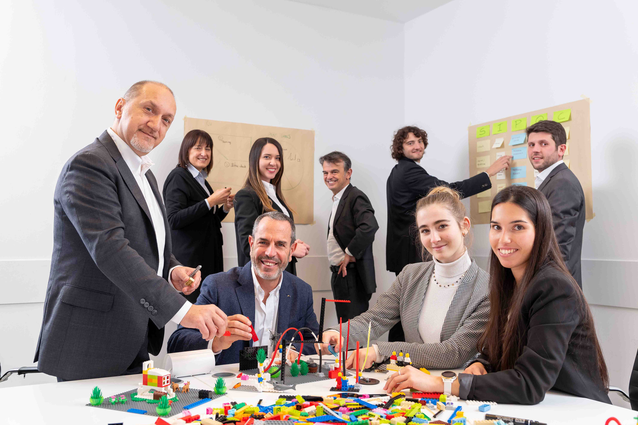 Foto business KyreTeam Colleghi che lavorano insieme con lego e lavagna